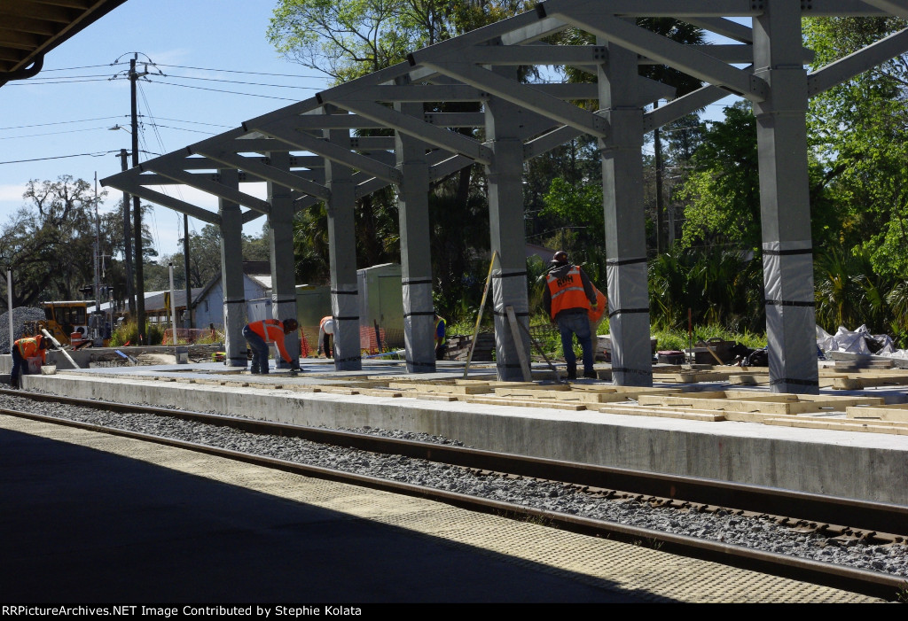 WORKER SMOOTHING CONCRETE ON PLATFROM